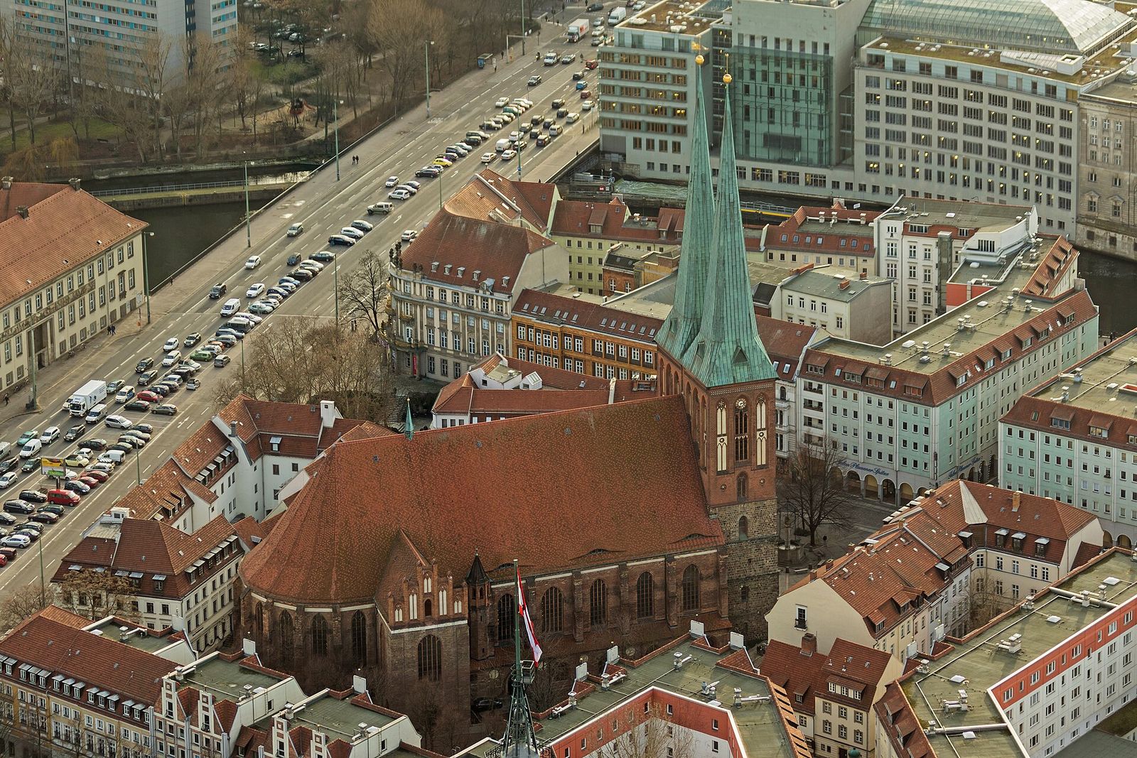 Blick aus der Höhe des Fernsehturms auf die Nikolaikirche mit ihren zwei spitzen Türmen und die roten Dächer des Nikolaiviertels