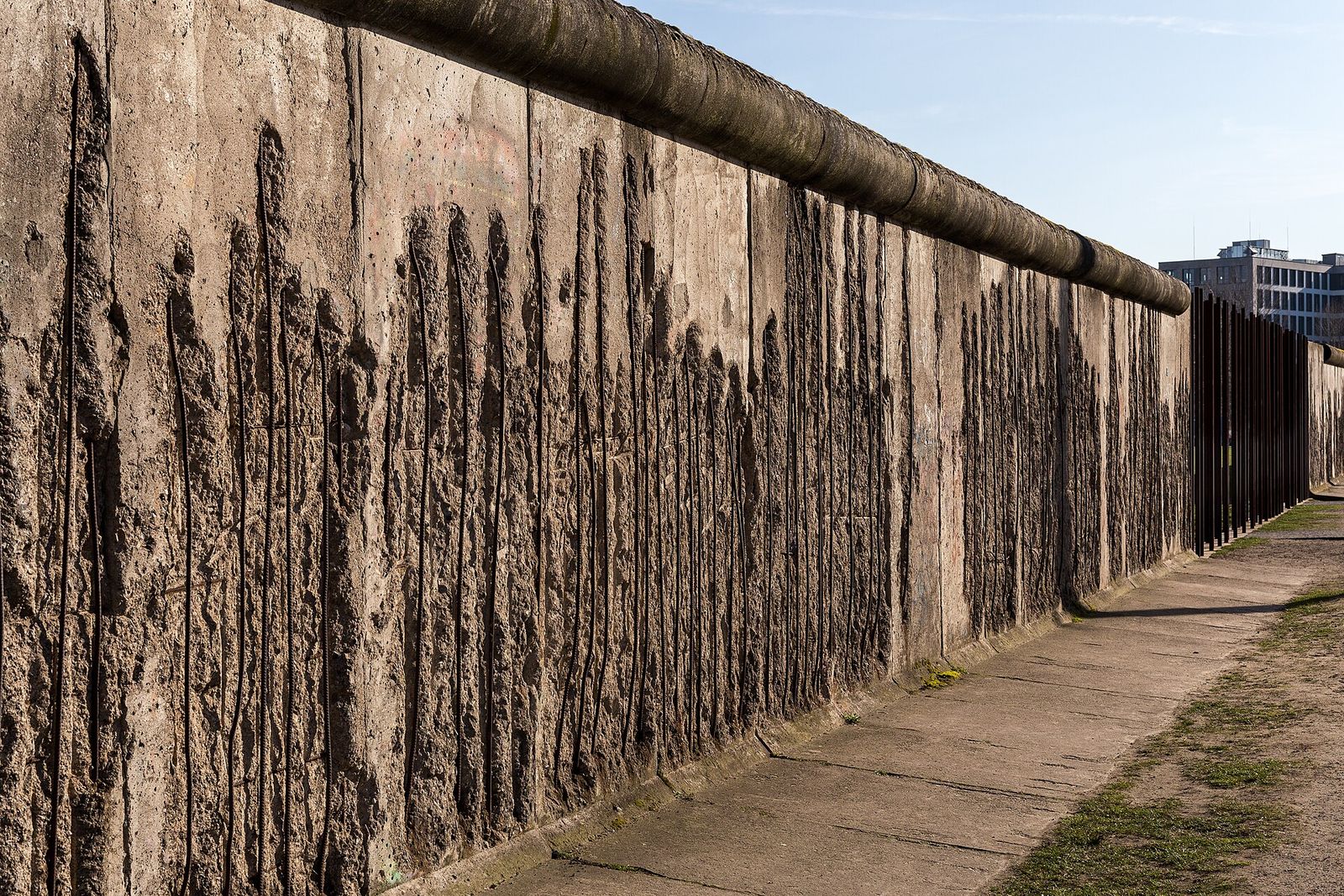 Erhaltenes Teilstück der Berliner Mauer an der Bernauer Straße, die Betonoberfläche ist von abgeschlagenen Stücken zerfurcht